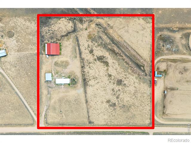 Aerial view of rural property outlined in red, with a home and outbuildings.