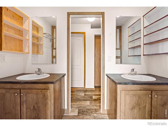 Bathroom with matching wood vanities and sinks facing each other across a central doorway.