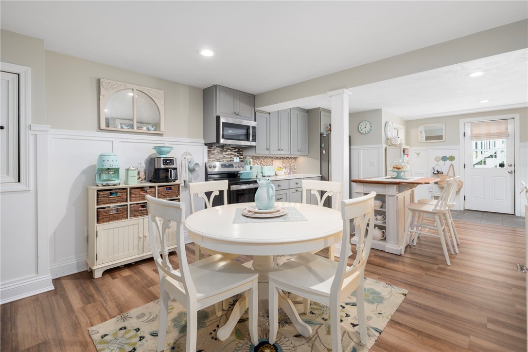 Kitchen and dining area with white cabinetry, an oval table, and a breakfast island.