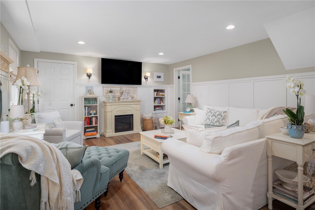 Living room with a fireplace, built-in shelving, and white sofas.
