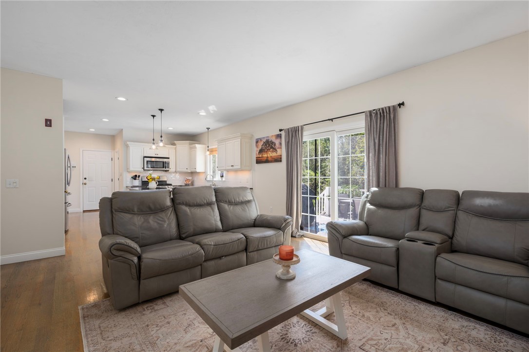 Living room with gray reclining sofas, a coffee table, and an open kitchen behind.