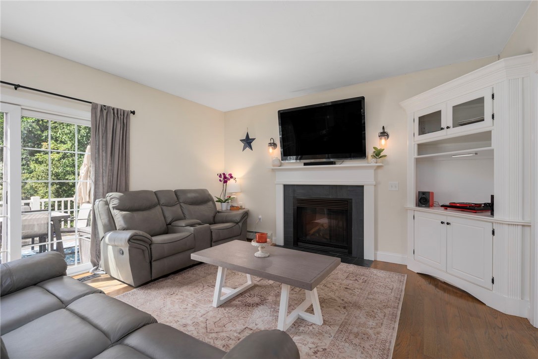 Living room with a fireplace, gray reclining sofas, built-in cabinets, and sliding glass doors.