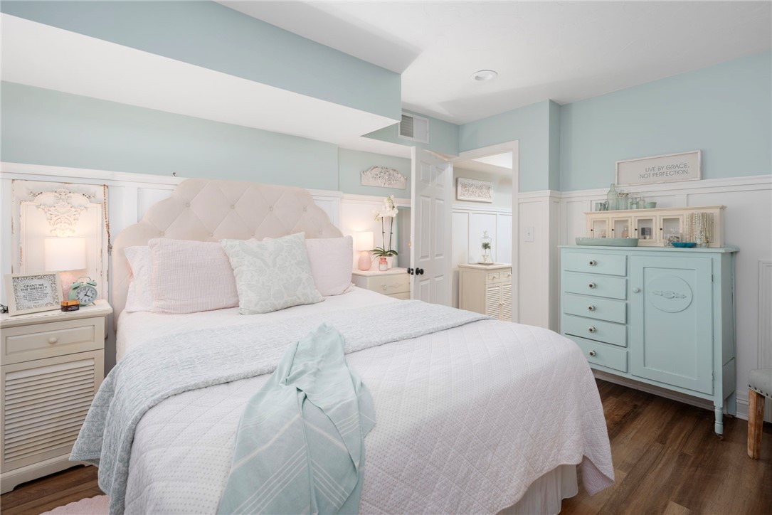 Bedroom with a tufted white headboard, pale aqua walls, and matching aqua dresser.