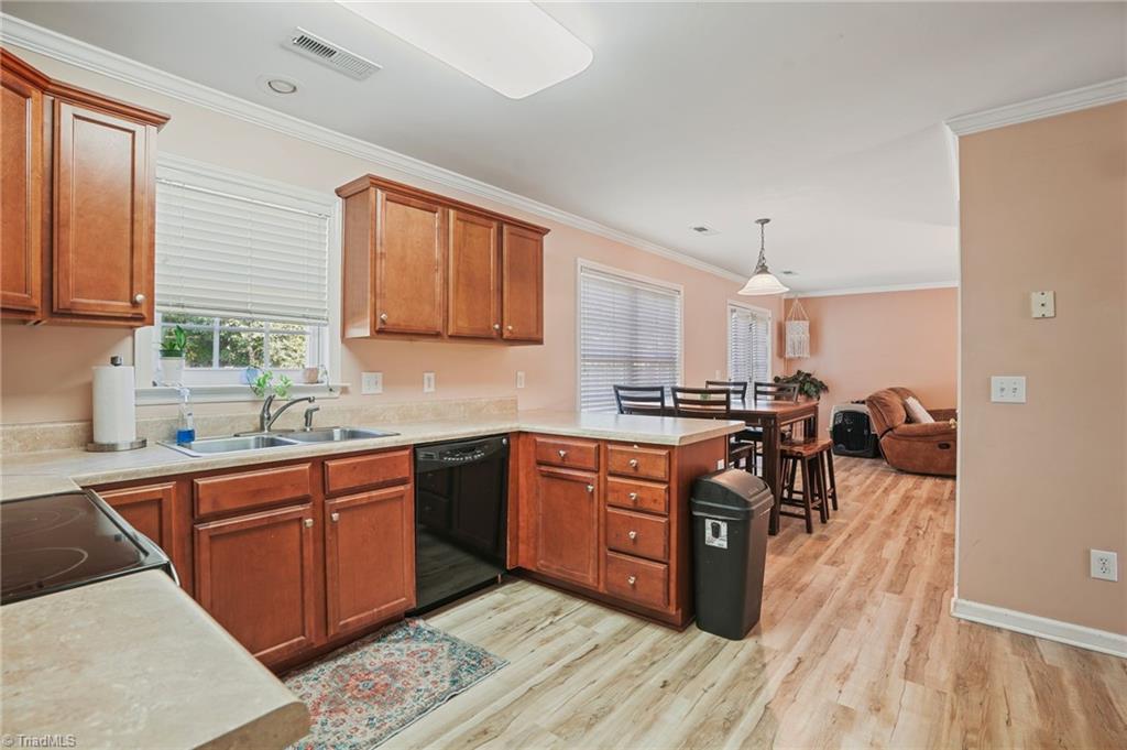 Open kitchen with reddish wood cabinets and a dining area beyond.