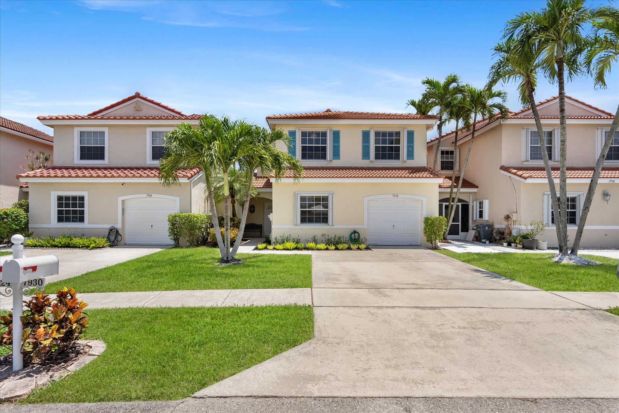 Two-story home at 7930 Nolting Court with a tiled roof, palm trees, and driveway.
