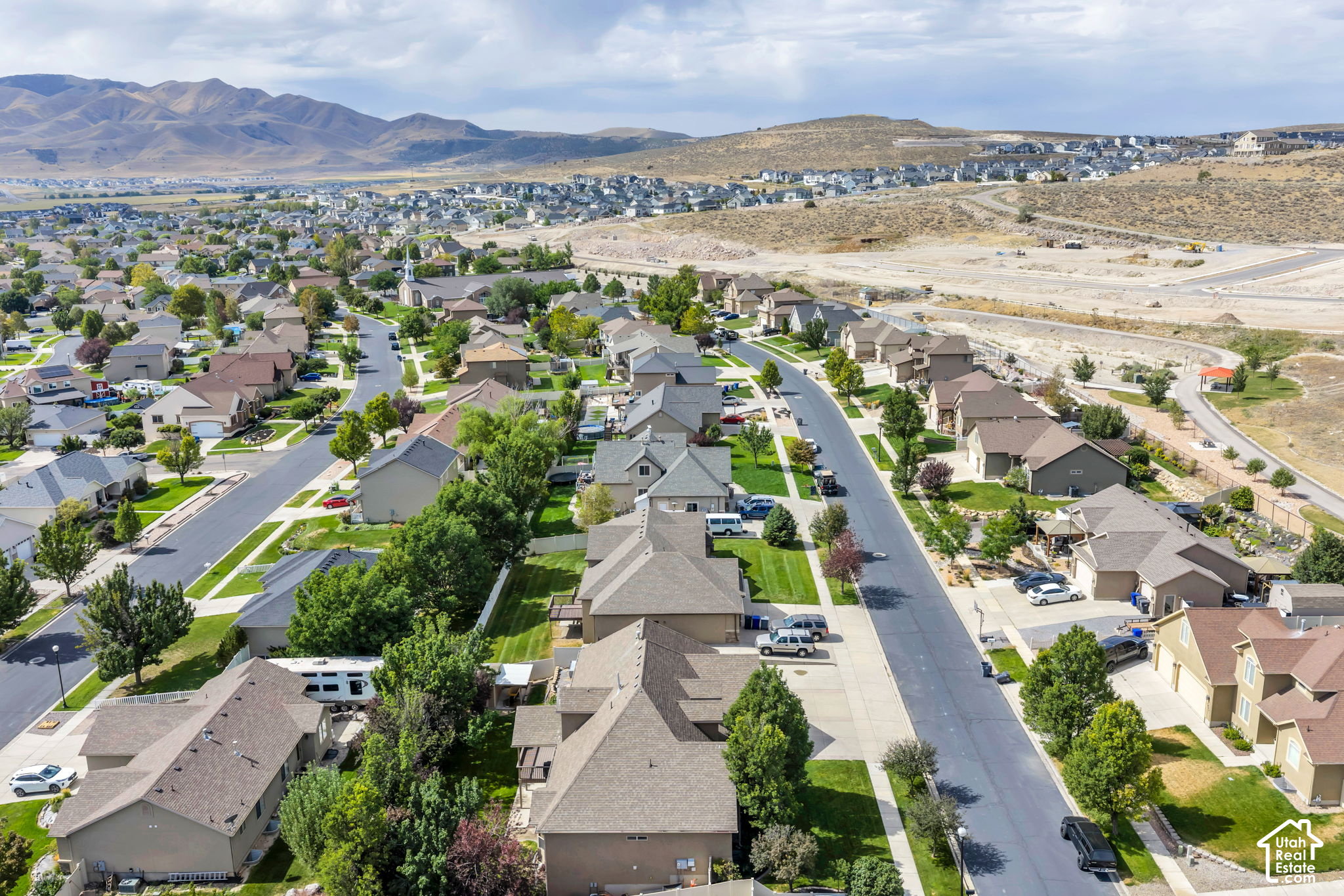 Aerial view of a suburban neighborhood with surrounding mountains and new construction.