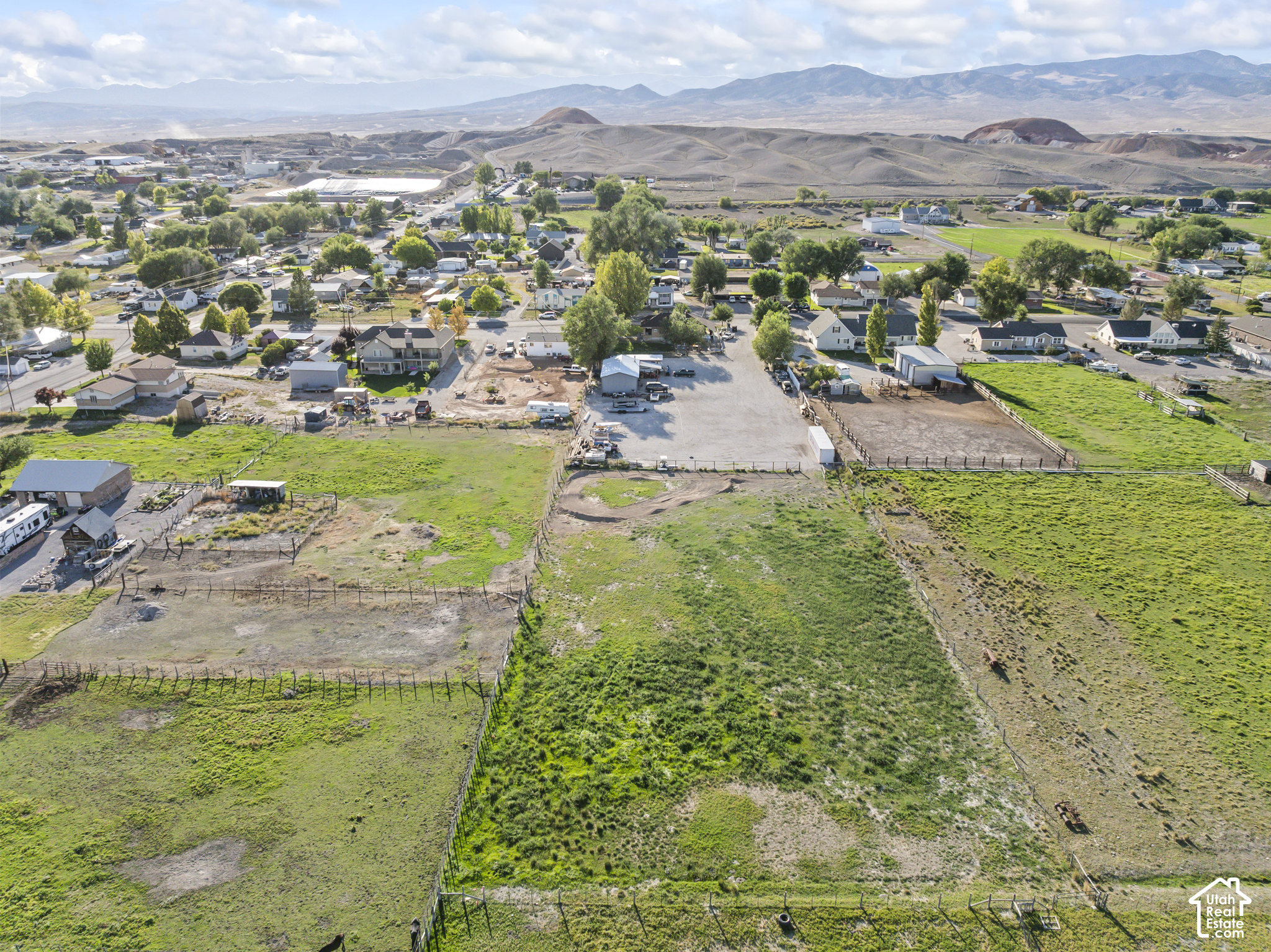 Fenced acreage near Redmond, with homes and mountain ranges in the distance.