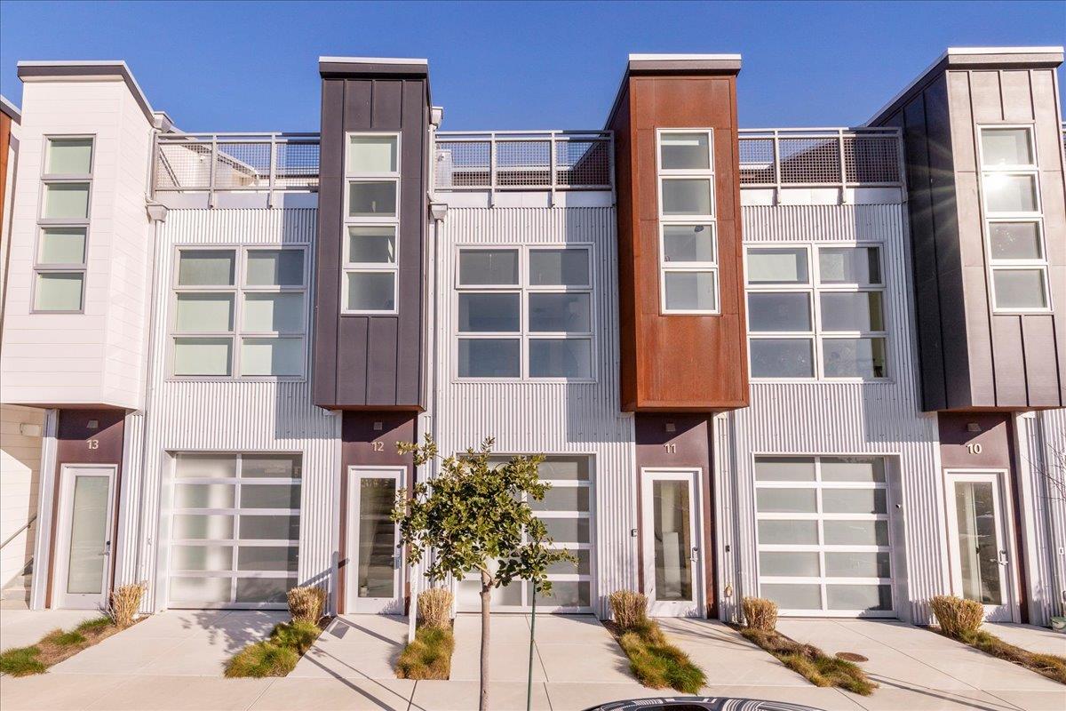 Modern townhome facade with rooftop terrace and unit 12 entrance.