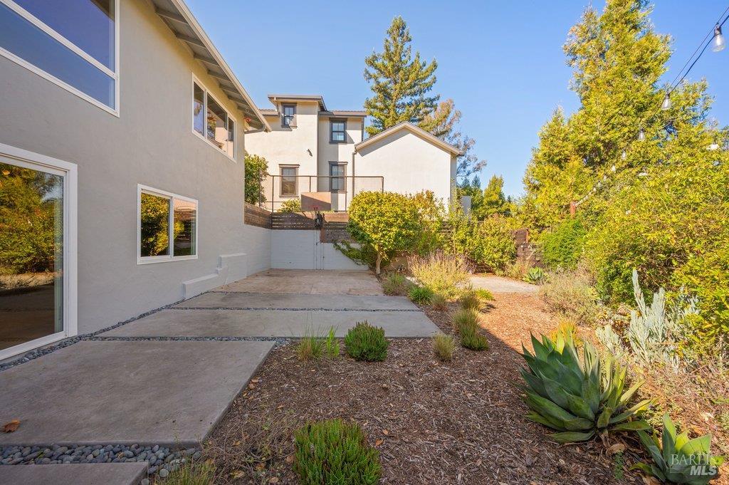 Home exterior with a concrete patio, gravel path, and drought-tolerant landscaping.