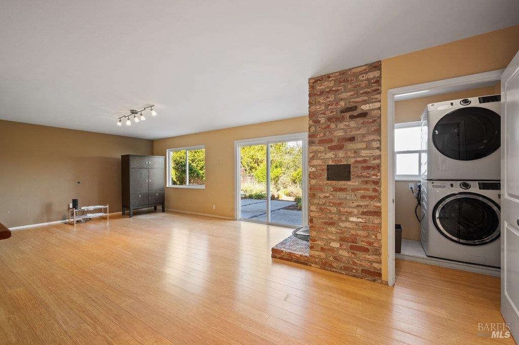 Living room with wood floors, a brick fireplace, and sliding doors to a patio.