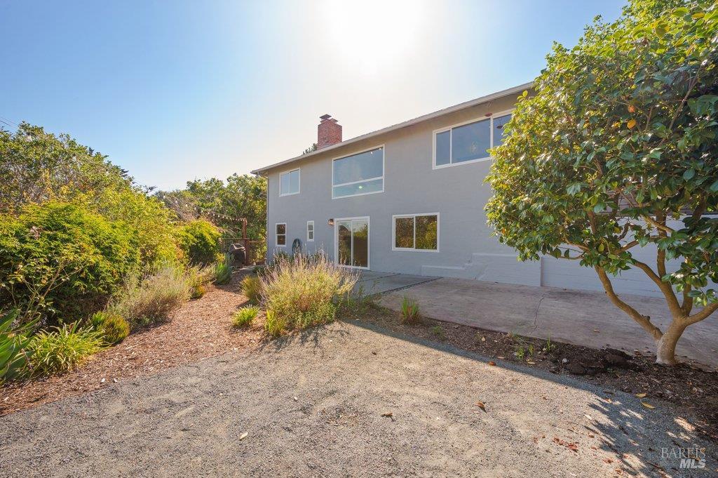 Two-story gray home with large windows, a garage, and a landscaped yard.