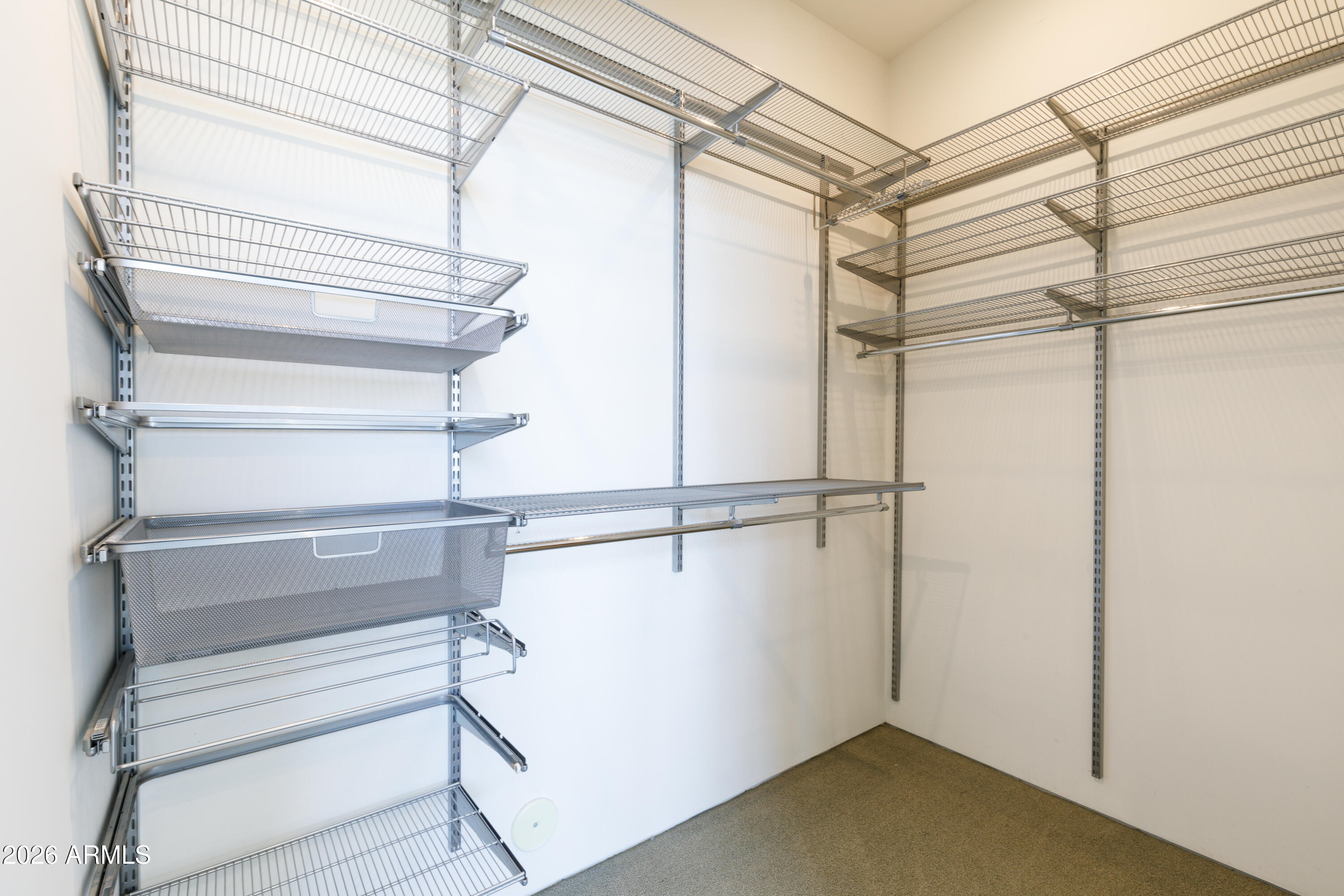 Walk-in closet with extensive metal wire shelving and mesh baskets.