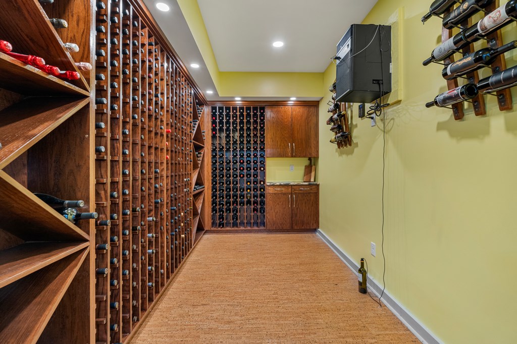 Wine cellar with extensive wooden bottle racks and built-in cabinets.
