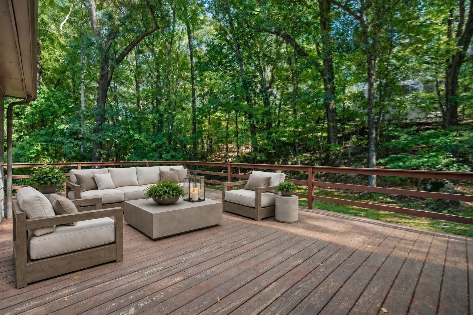 Furnished wooden deck with cushioned seating overlooking dense trees.