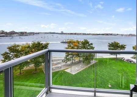 Balcony overlooking a waterfront lawn and harbor.