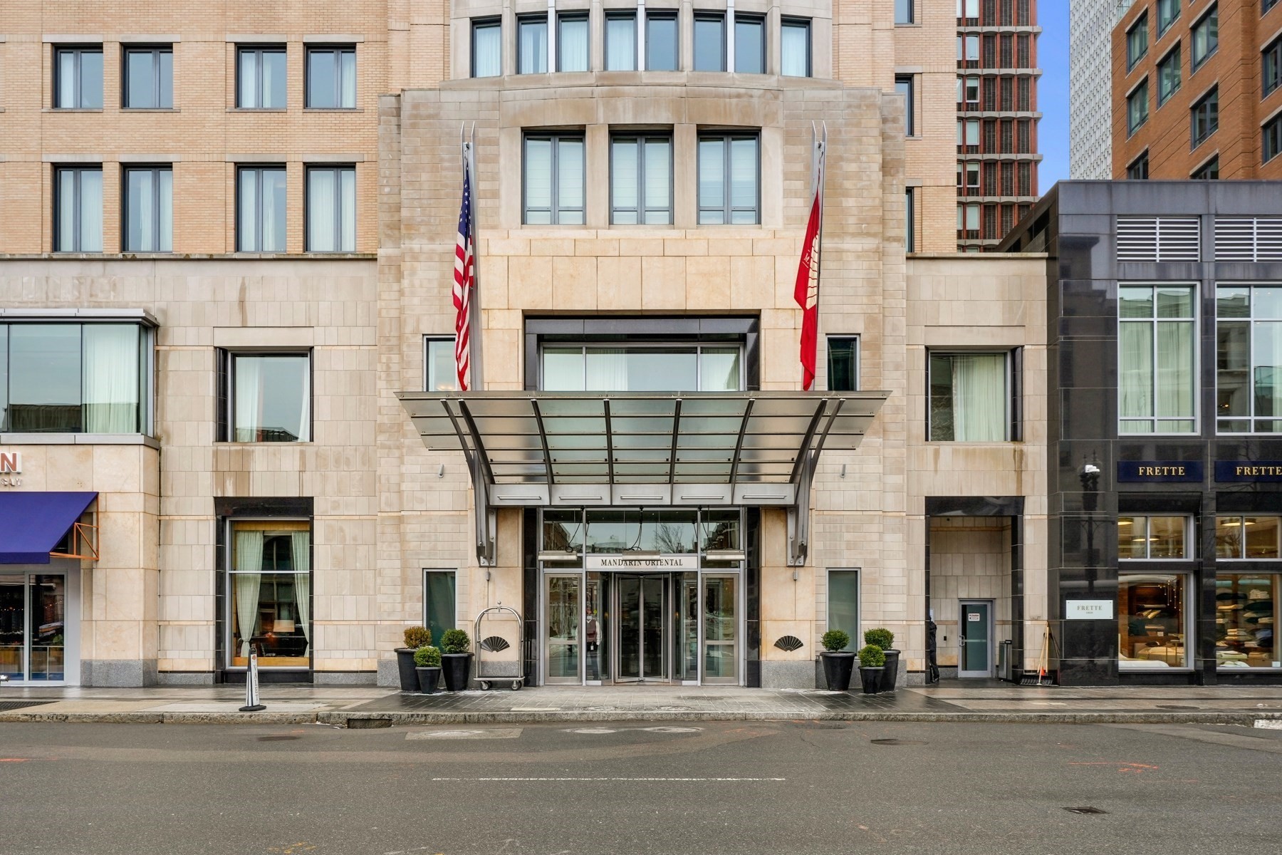 Mandarin Oriental building entrance with a broad glass canopy and flags.