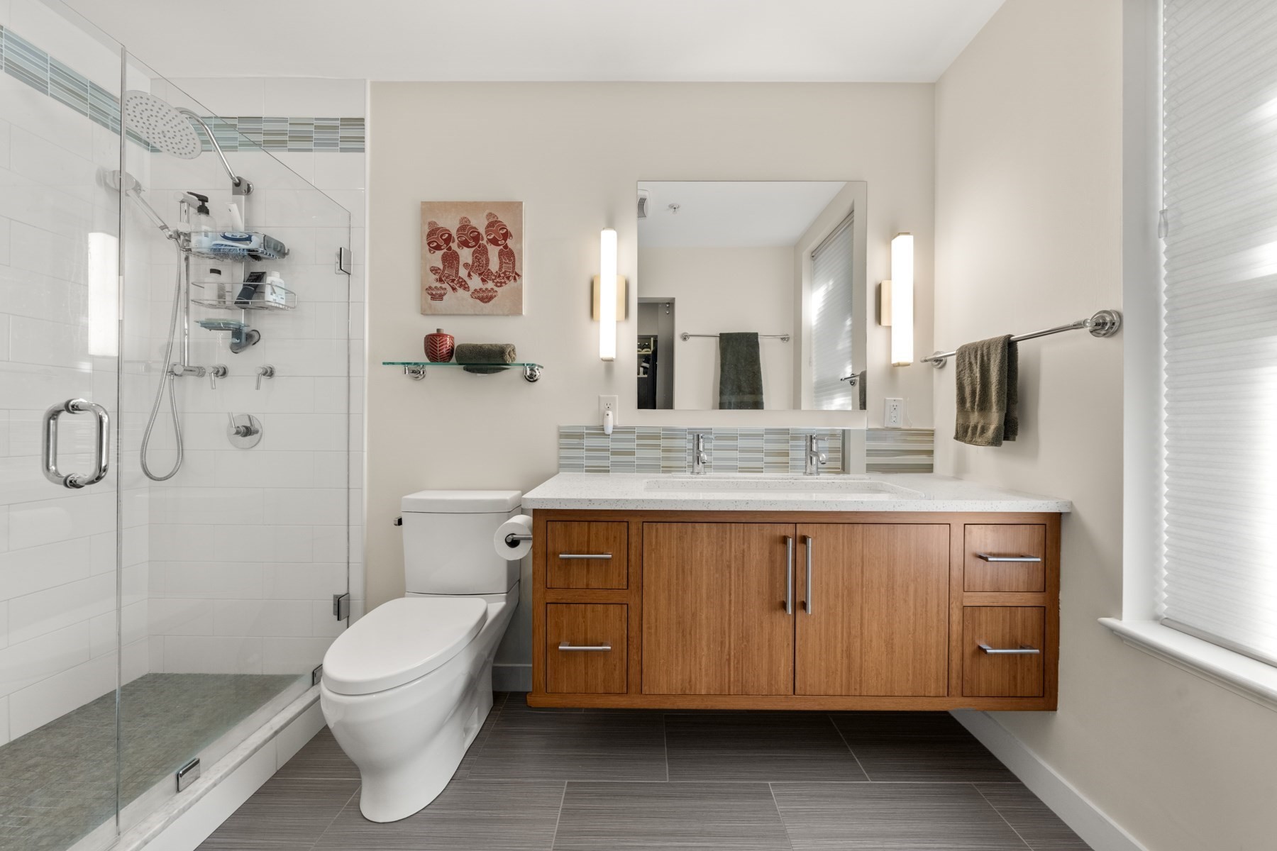 Modern bathroom with glass walk-in shower and a wide wood double-sink vanity.