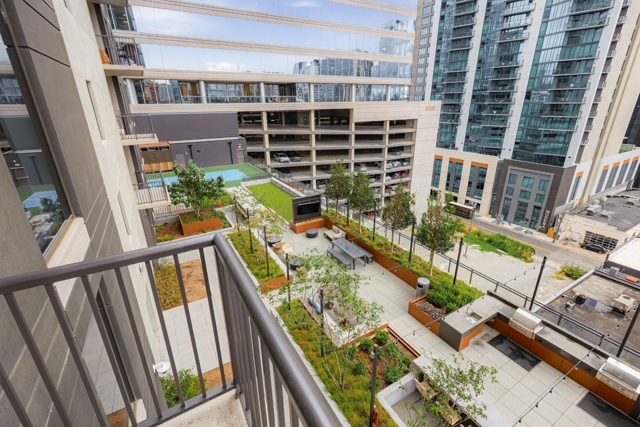 Condominium courtyard terrace with raised gardens, seating, a sport court, and outdoor grills.