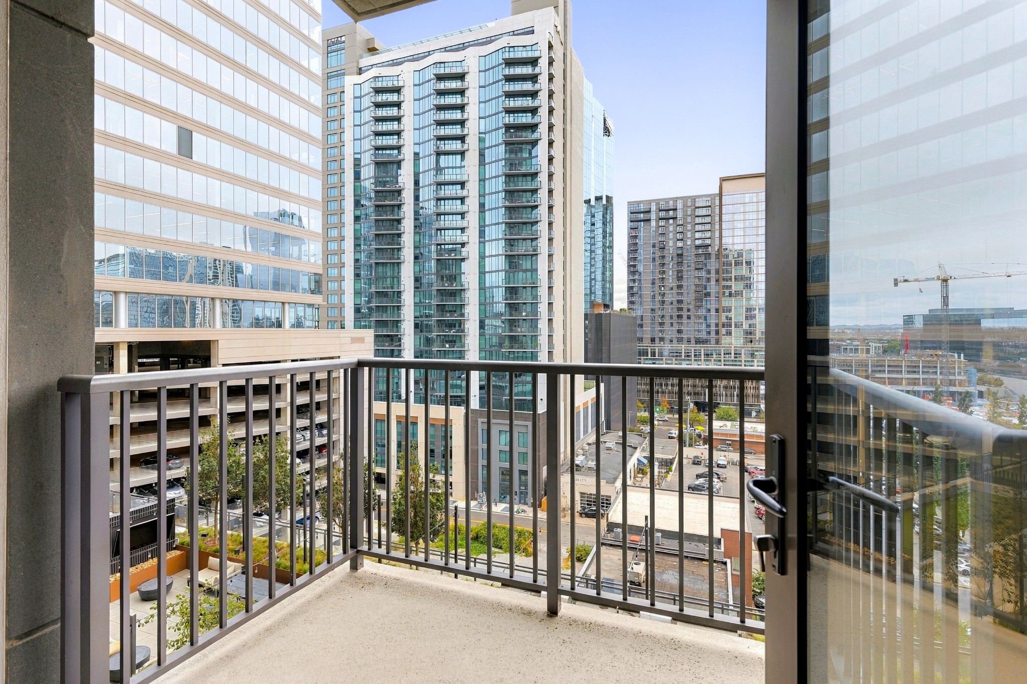 High-rise condo balcony overlooking downtown towers and a construction crane.