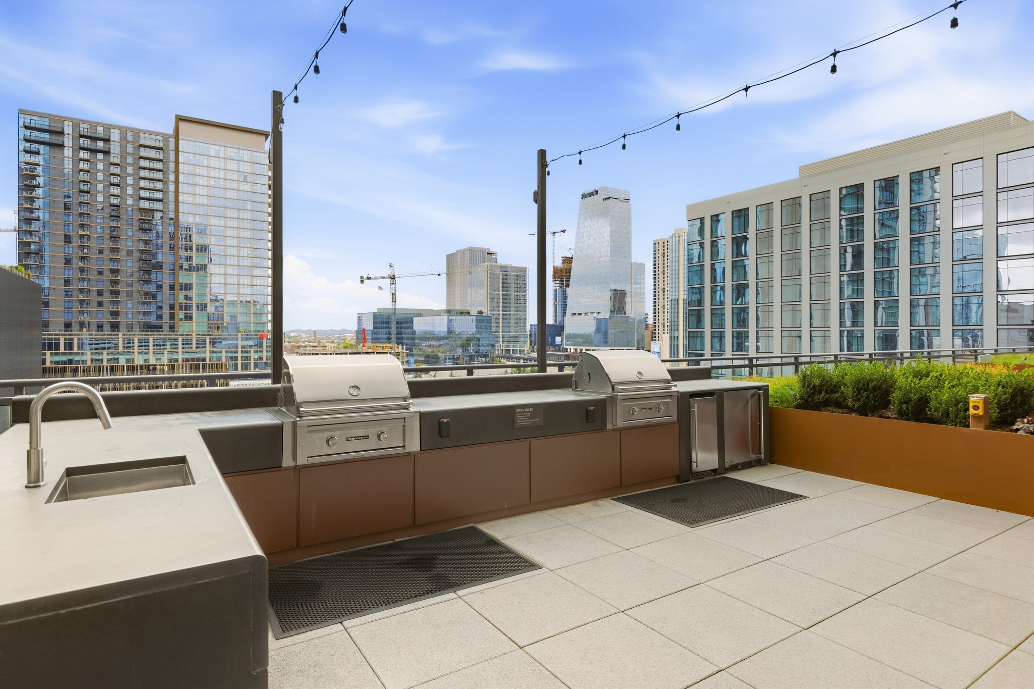 Rooftop terrace with two stainless-steel grills and a downtown Nashville skyline view.