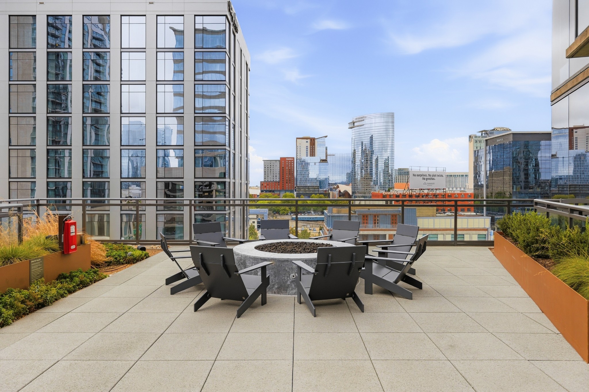 Rooftop terrace with a circular fire pit and lounge chairs overlooking downtown Nashville.