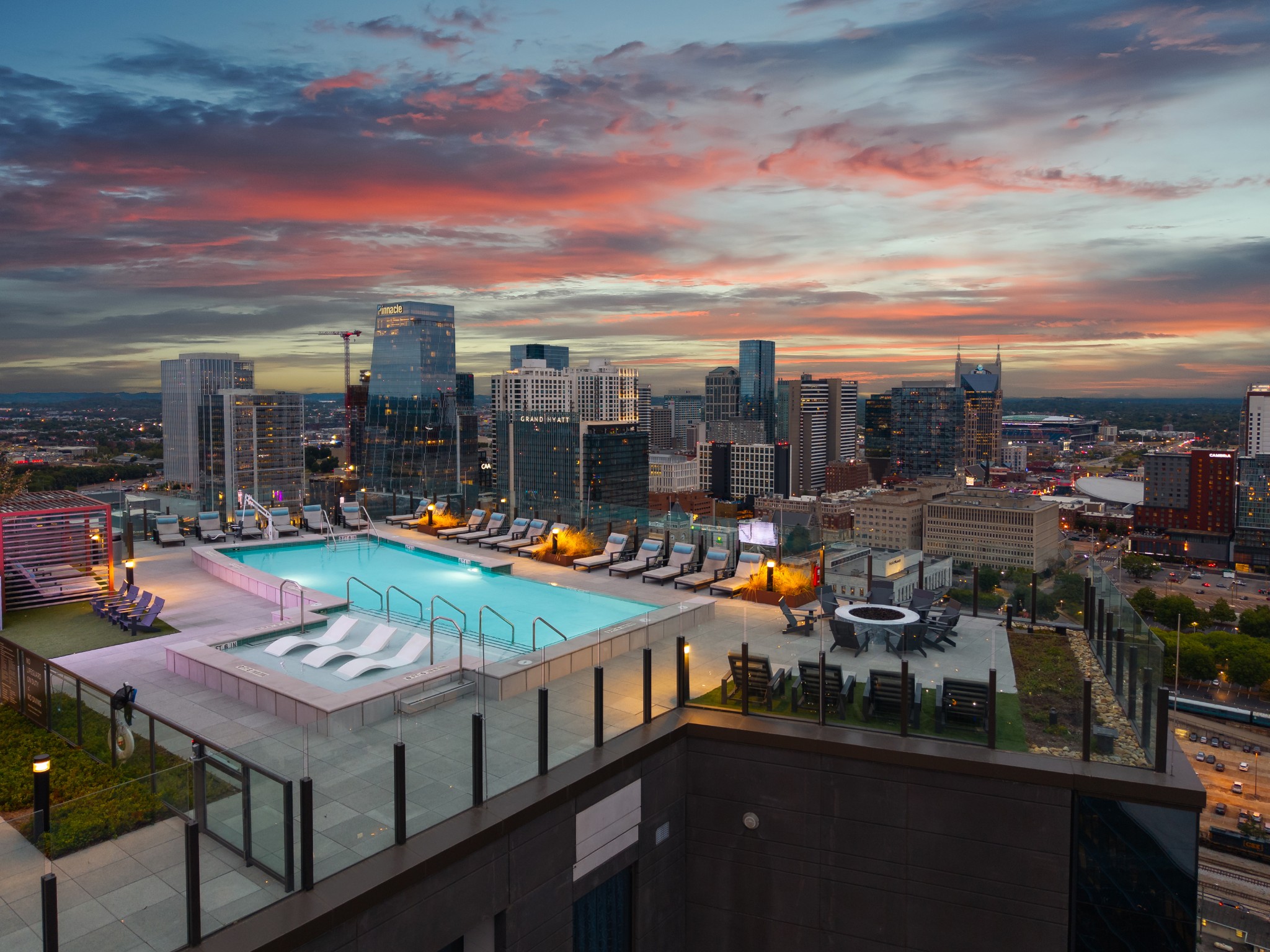 Rooftop pool and lounge terrace overlooking downtown Nashville at dusk.