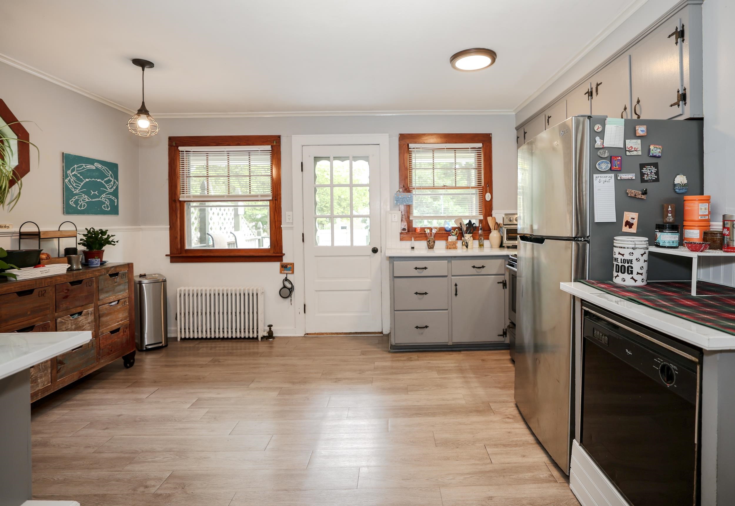 Kitchen with gray cabinets and stainless steel appliances, viewed toward a glass-paneled back door.