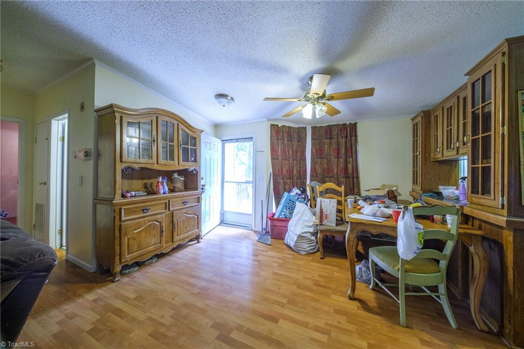 Dining area with built-in wooden cabinetry, a crowded table, and a glass door to the porch.