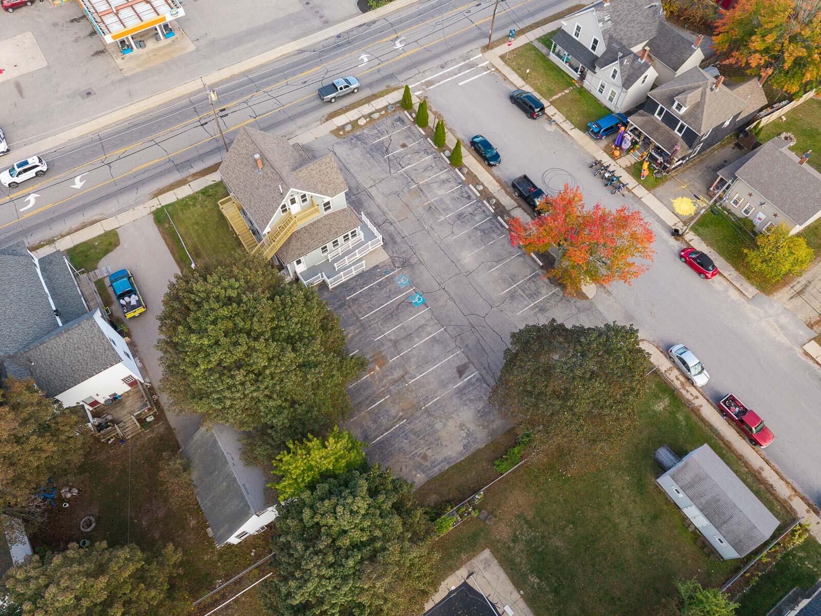 Aerial view of a multi-story building beside a large parking lot and Main Street.