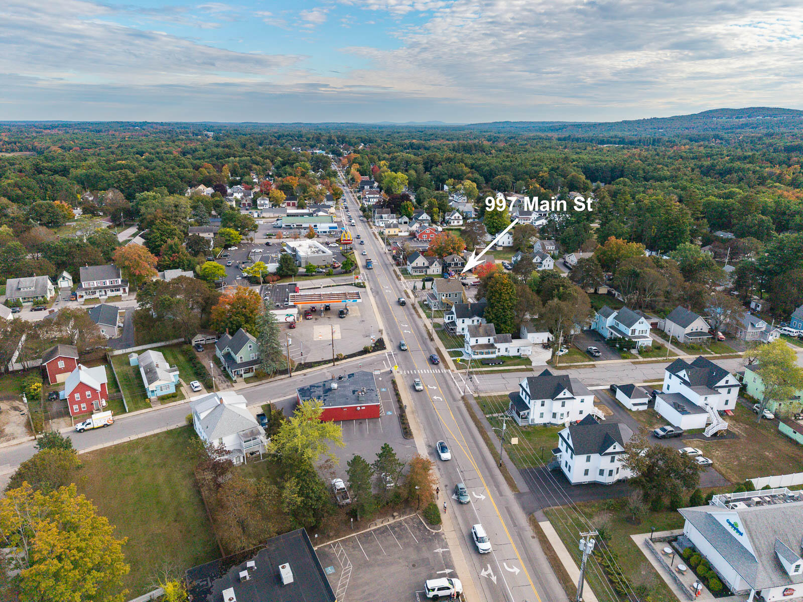 Aerial view of 997 Main Street amid Sanford homes and businesses, marked by an arrow.
