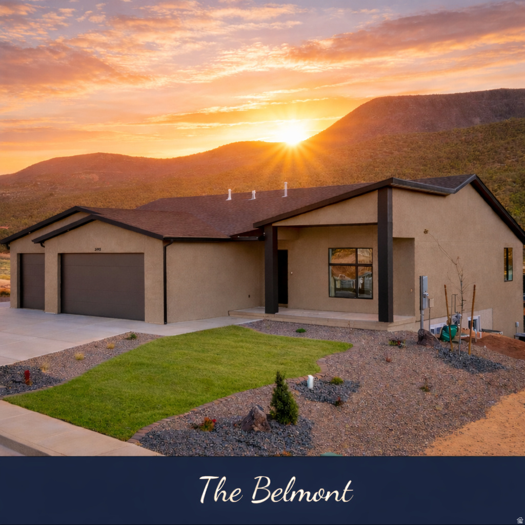 The Belmont home with a double garage and landscaped lawn against mountains at sunset.