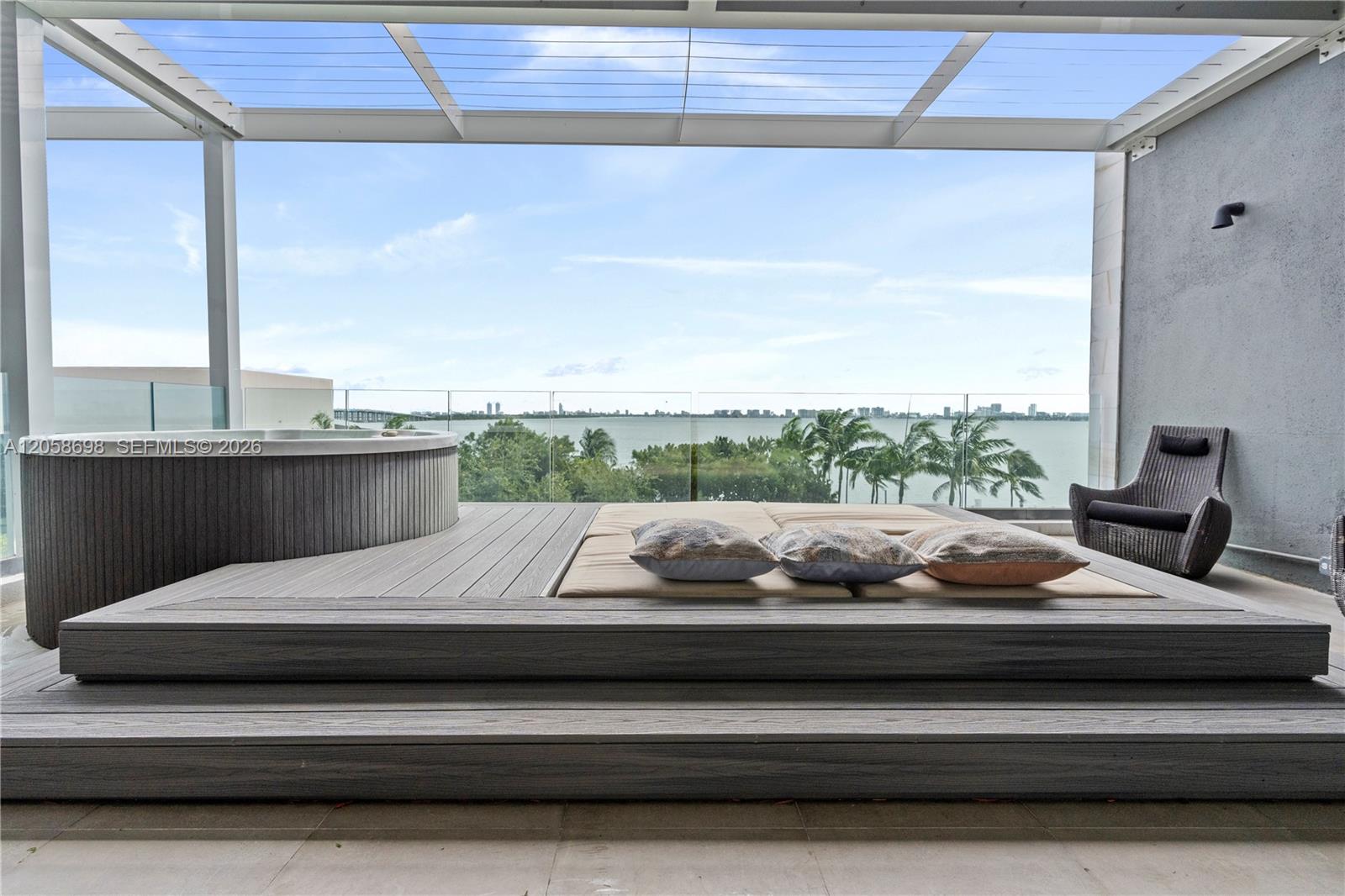 Waterfront terrace with a hot tub and cushioned platform overlooking the bay.
