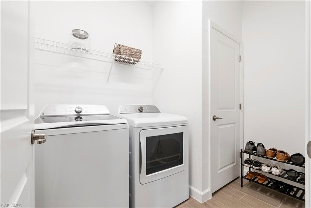 Laundry room with a washer and dryer, wire shelf, and shoe rack.