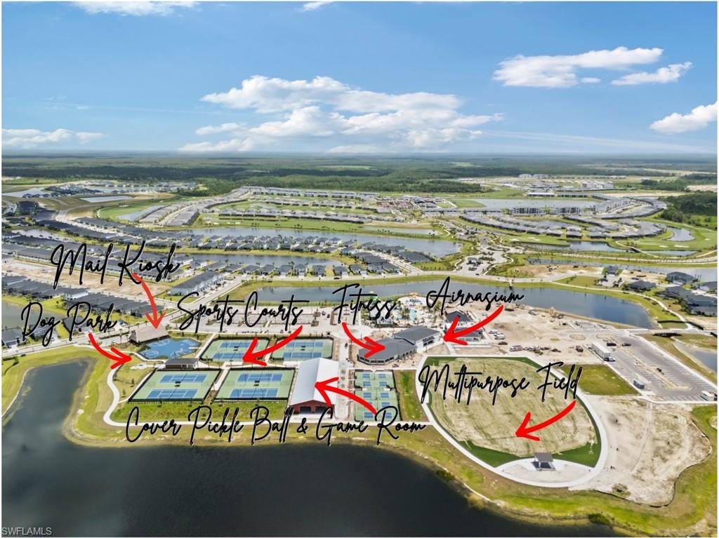 Aerial view of a lakefront community’s sports courts, fitness center, dog park, and multipurpose field.