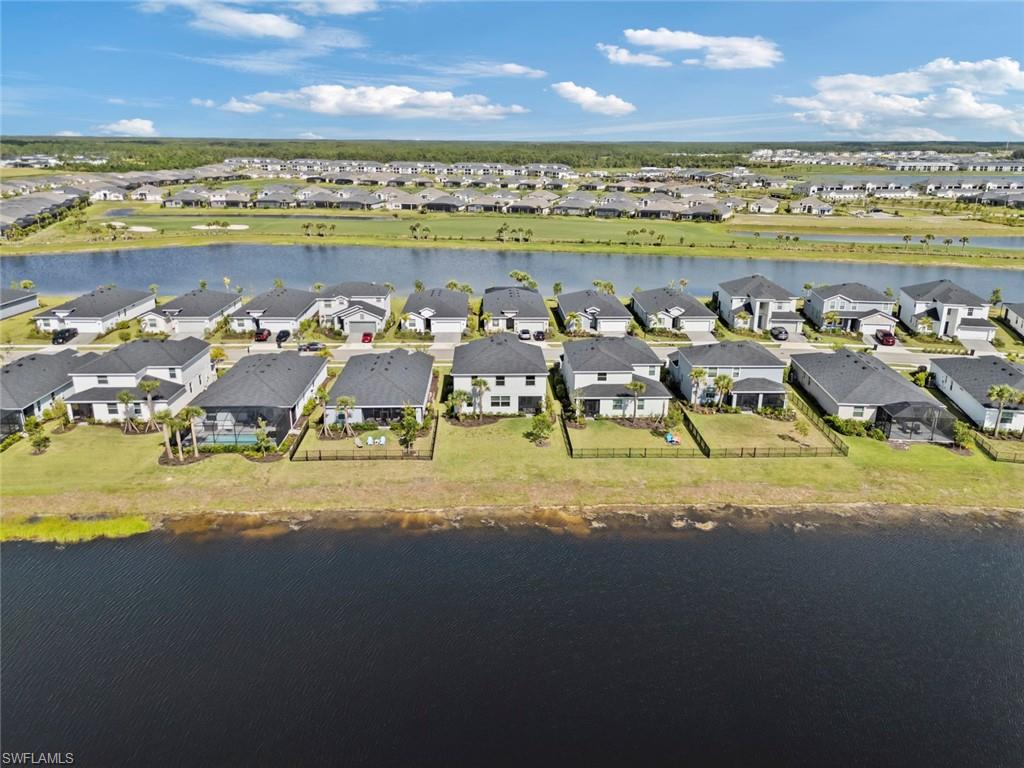 Aerial view of homes lining a lake, with a residential neighborhood stretching into the distance.
