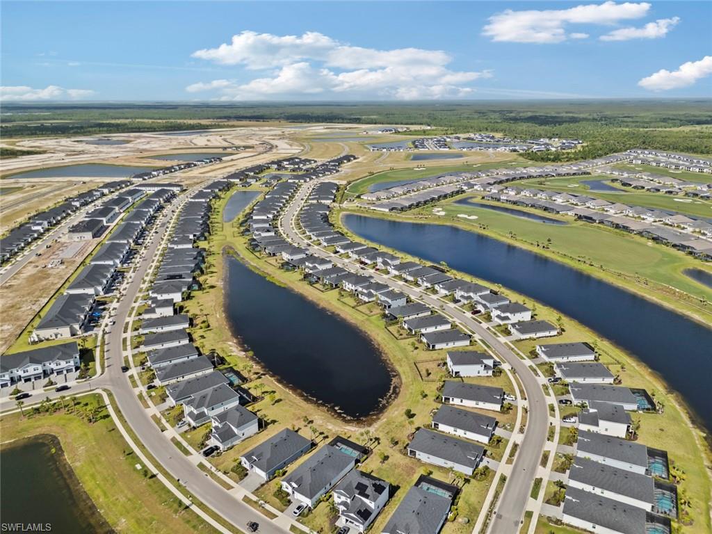 Aerial view of a residential neighborhood with rows of homes and ponds.
