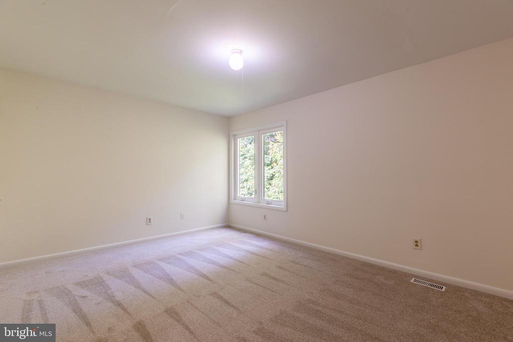 Empty carpeted bedroom with a double window and ceiling light.
