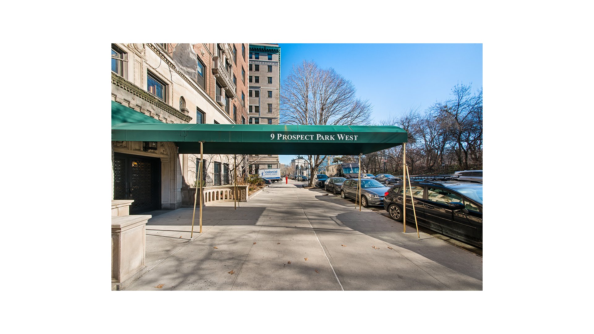 Apartment building entrance beneath a green 9 Prospect Park West awning, with parked cars and leafless trees.