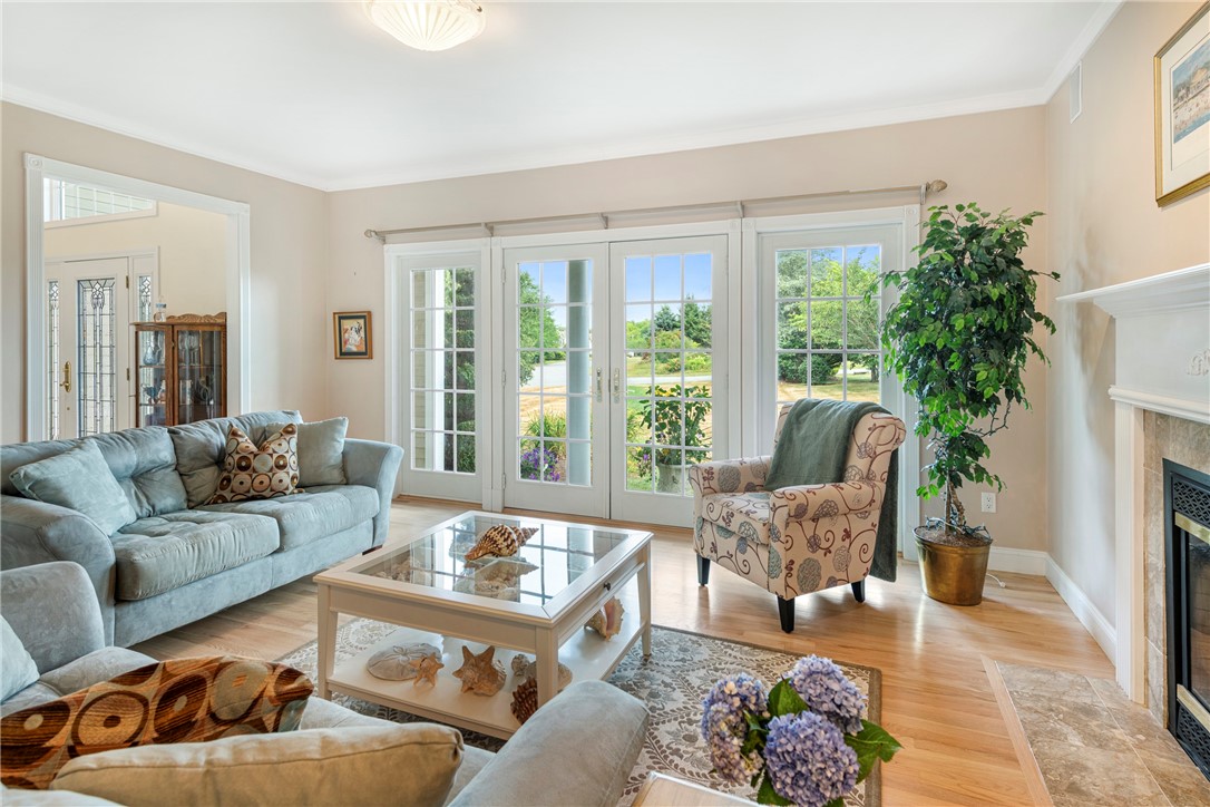 Living room with a pale blue sectional, patterned armchair, and French doors overlooking a green yard.