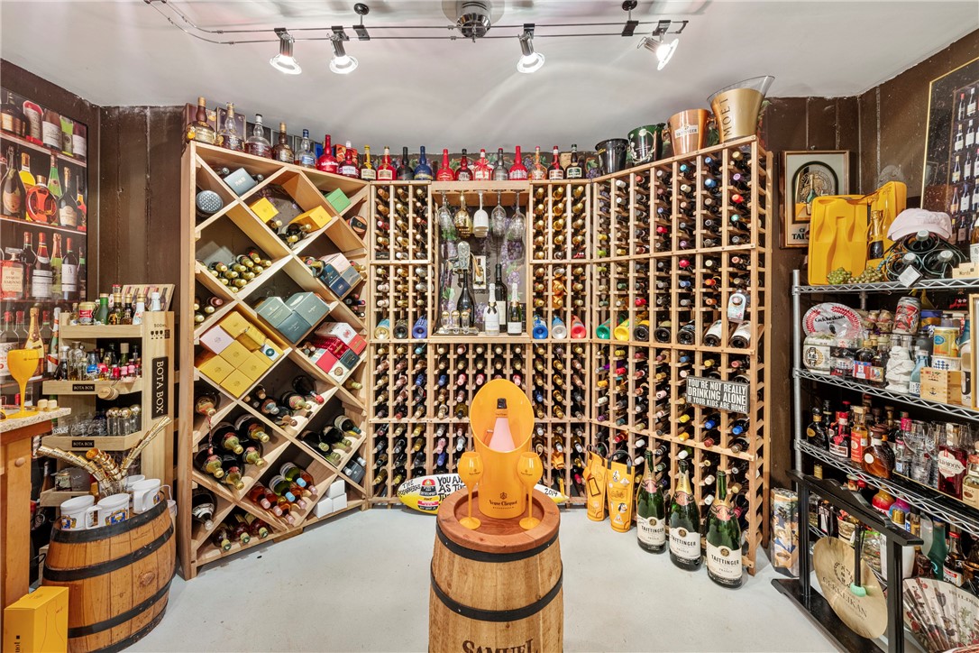 Wine cellar with extensive wooden bottle racks and champagne displayed on barrels.
