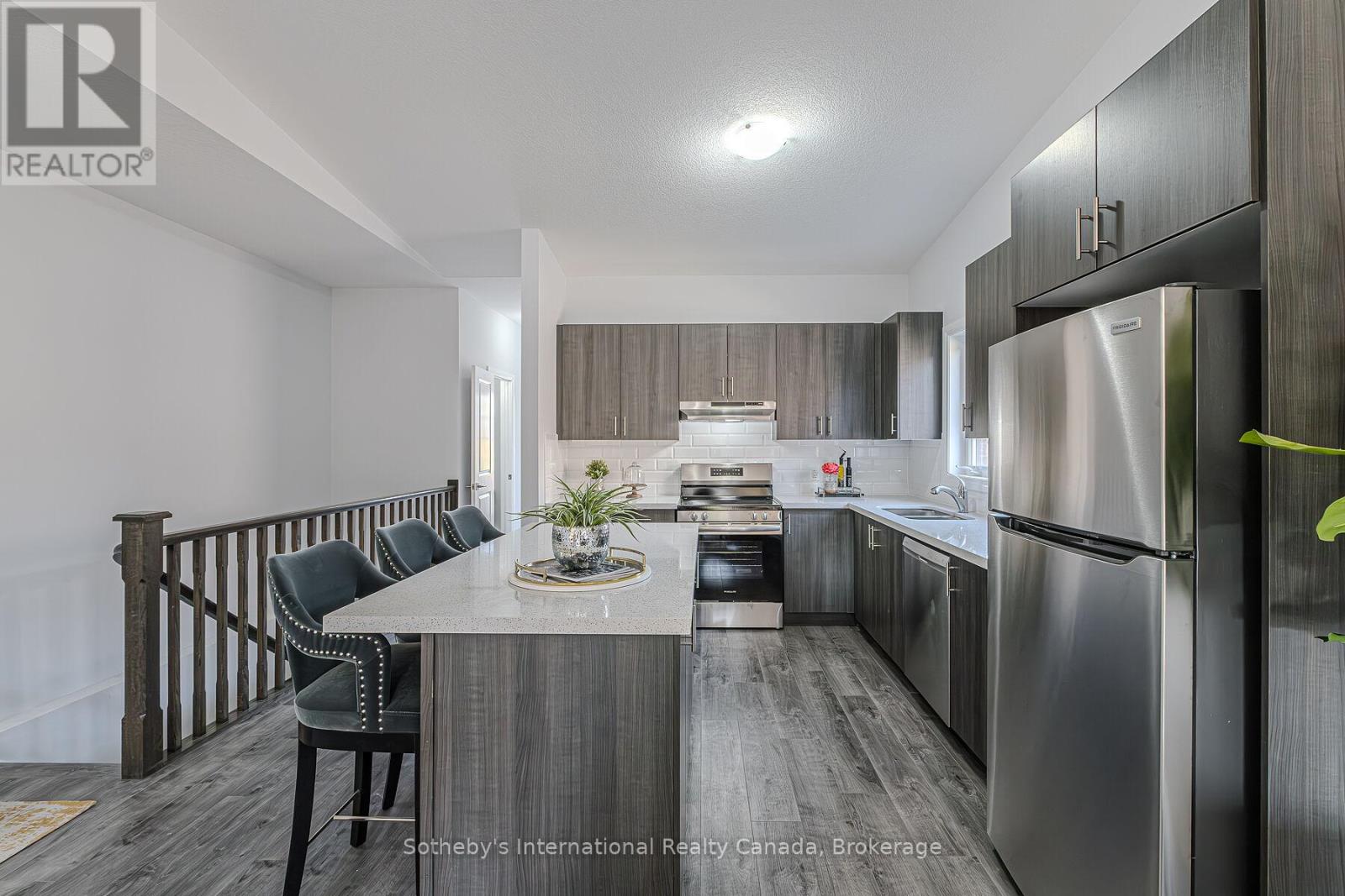 Kitchen with dark wood cabinets, stainless steel appliances, and a central island with seating.