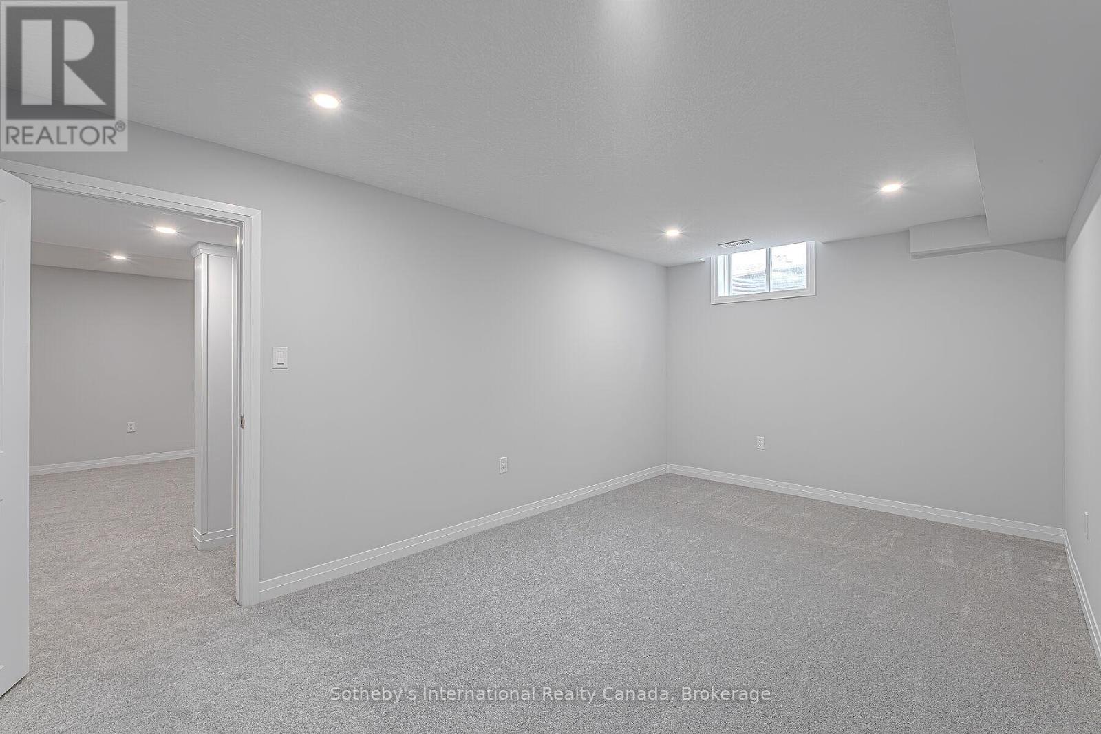 Unfurnished carpeted room with recessed lights, a small high window, and an open doorway.