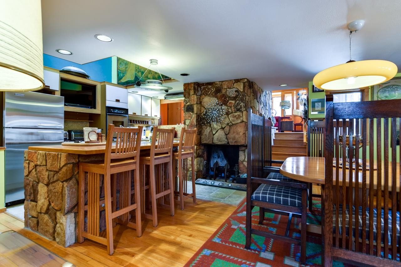 Kitchen and dining area with a stone breakfast bar and a large stone fireplace.