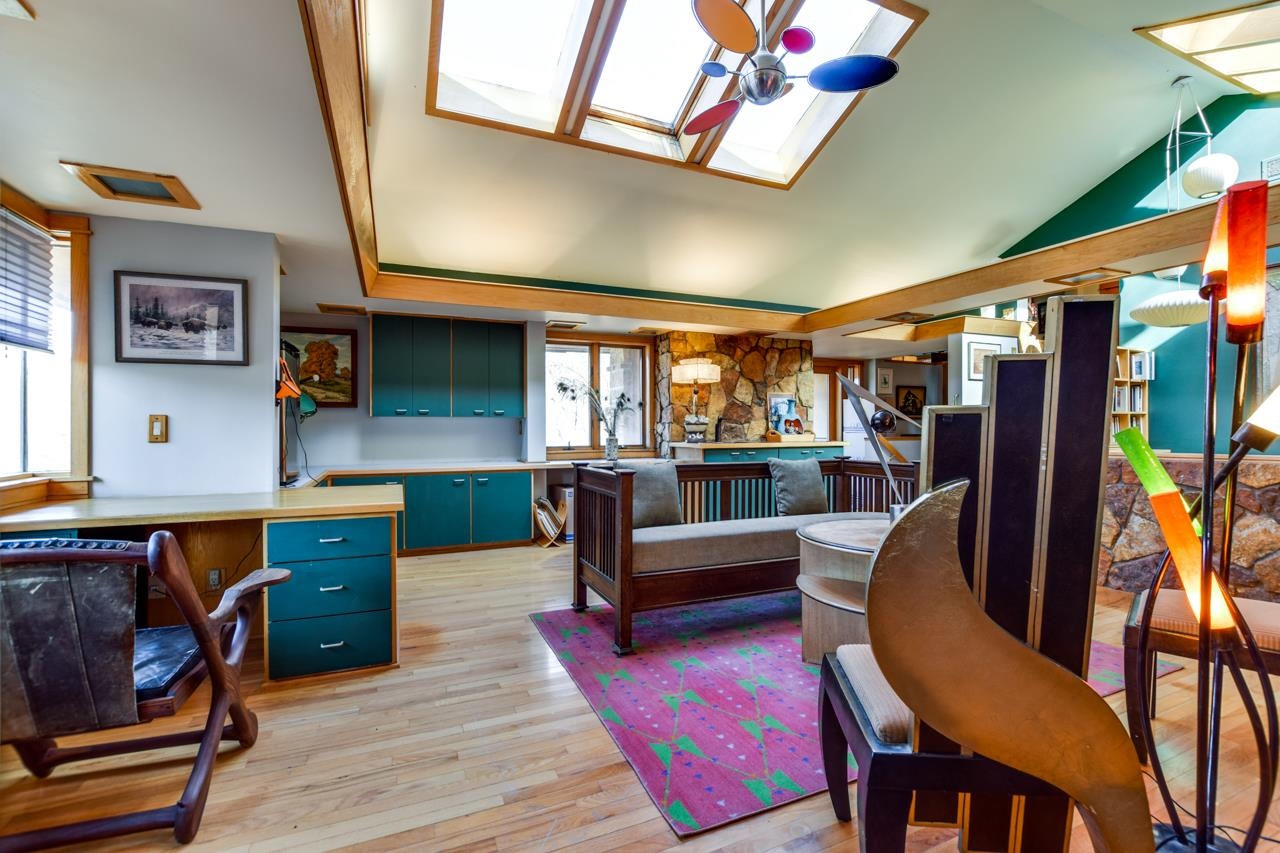 Open living area with skylights, teal cabinetry, and a stone accent wall.