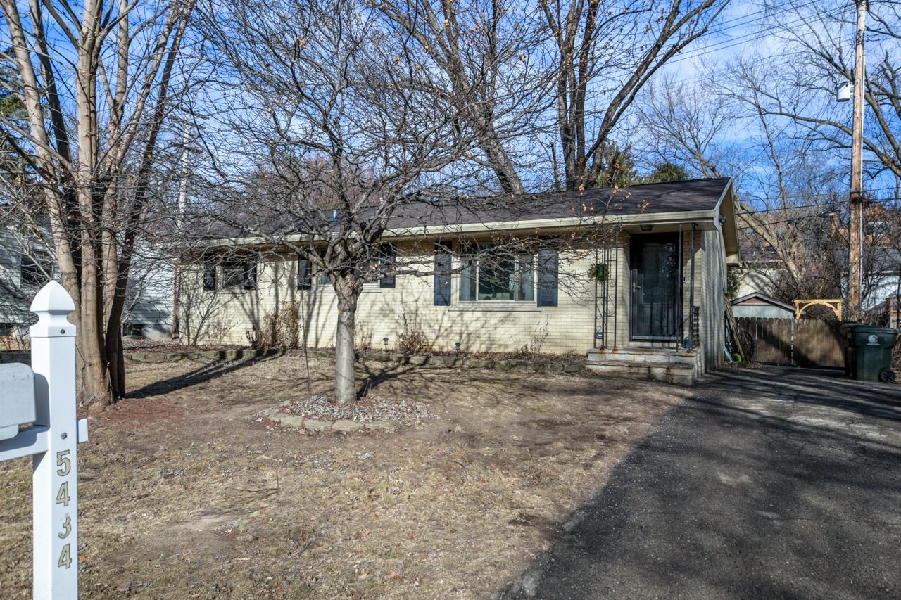 Single-story house with a dark roof, leafless trees, and driveway; mailbox shows number 5434.