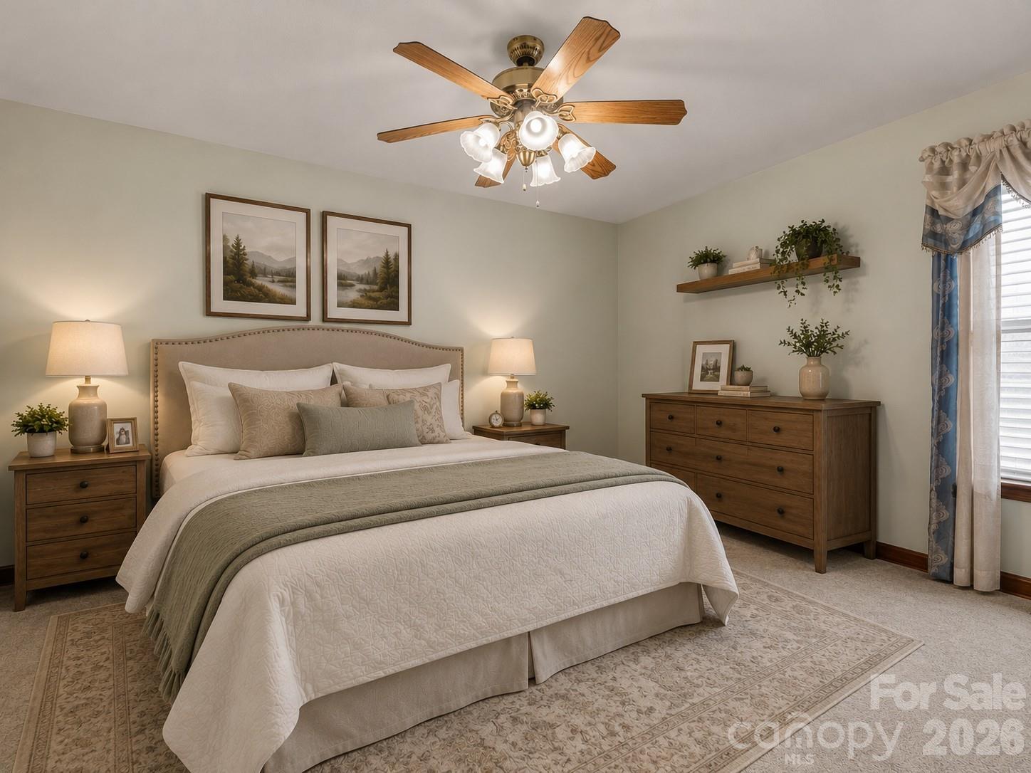 Furnished bedroom with a cream bed, green throw, wooden furniture, and a ceiling fan.
