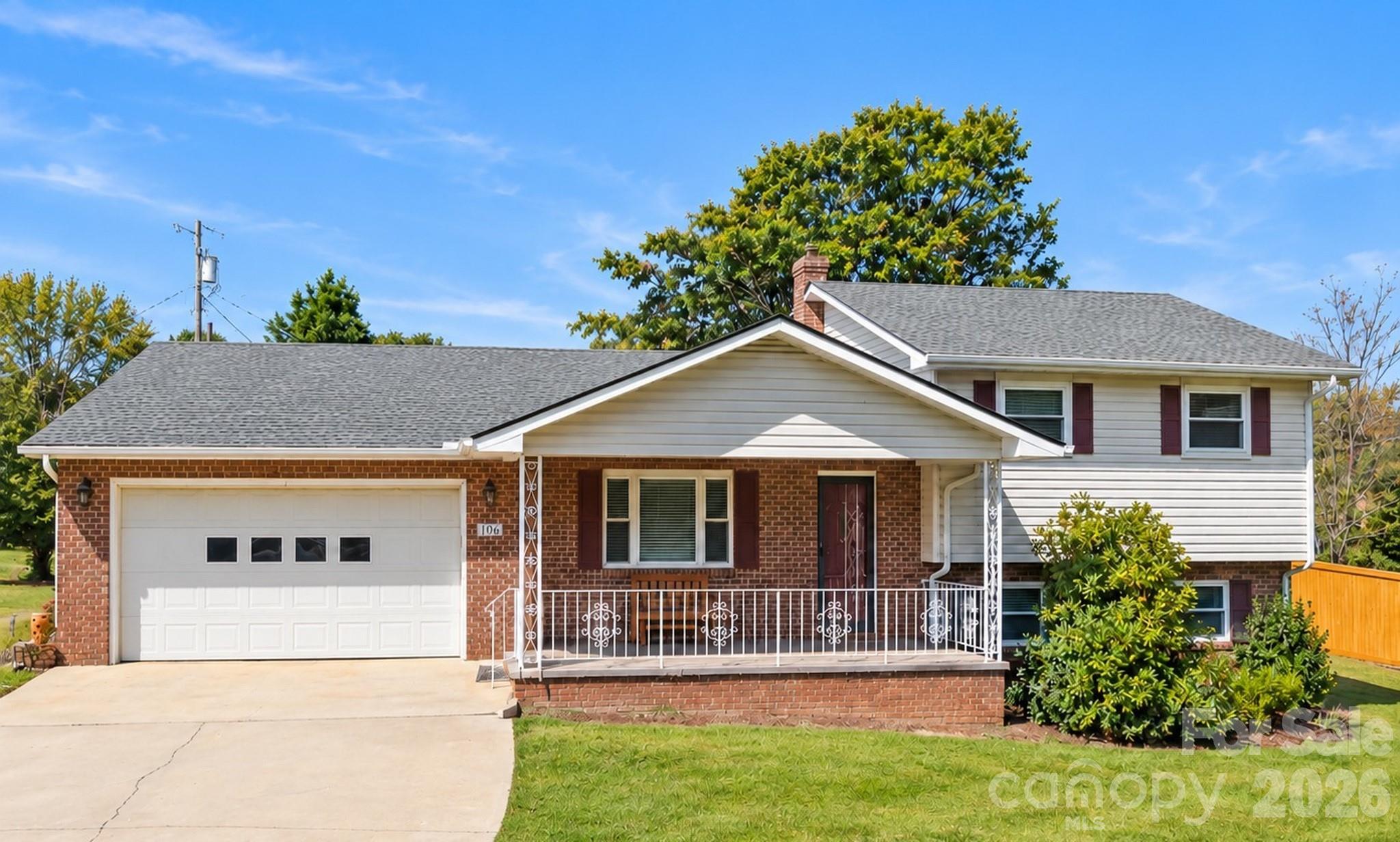 Two-level brick and siding house with an attached garage and covered porch.