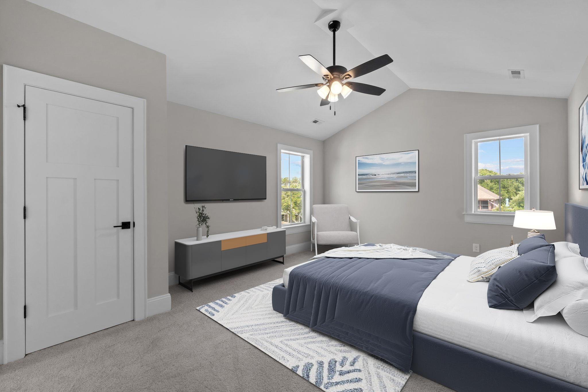 Bedroom with a slate-blue bed, vaulted ceiling, ceiling fan, and wall-mounted television.