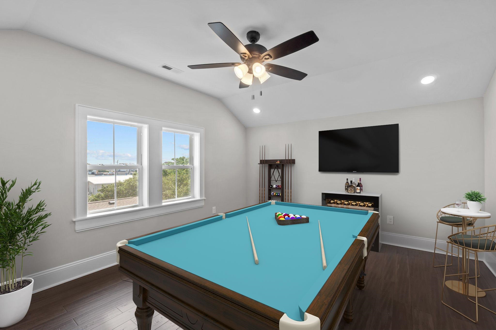 Game room with a turquoise pool table, billiard balls, wall-mounted television and large windows.