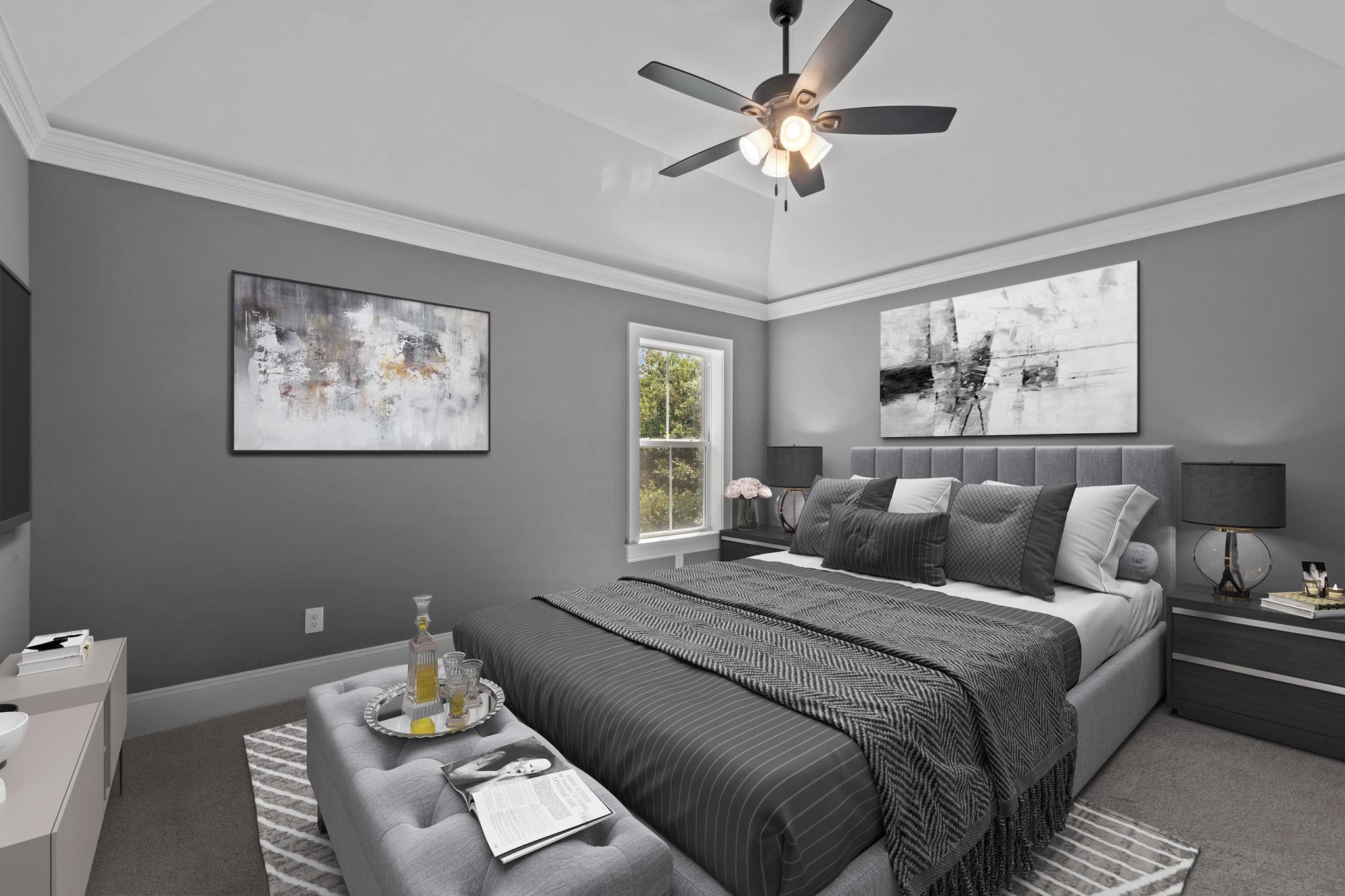 Staged bedroom with a gray upholstered bed, layered bedding, abstract art, and a lit ceiling fan.